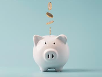 Coins dropping into a piggy bank