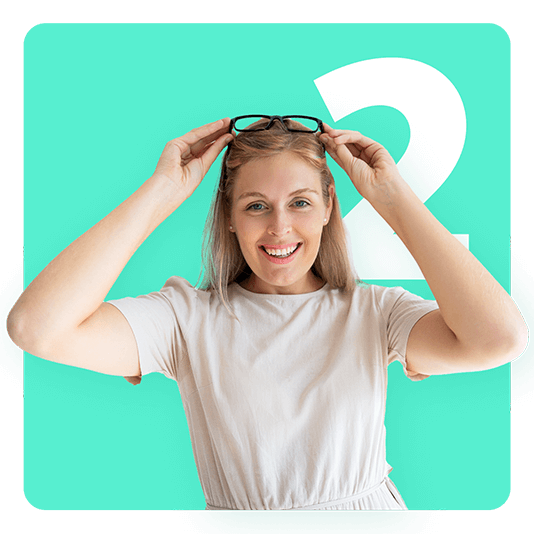 Woman reaching for glasses on her head and smiling
