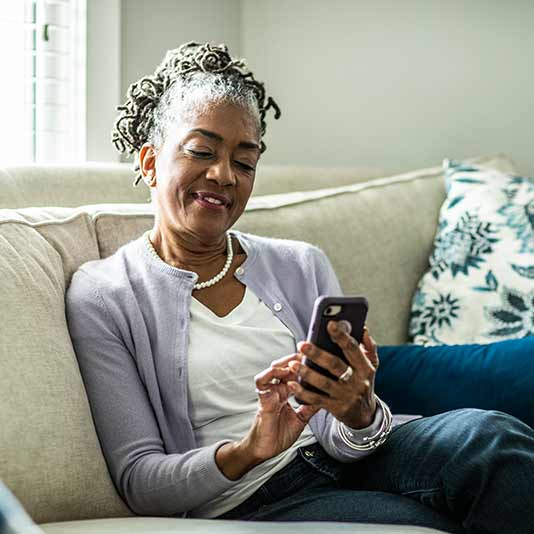 Woman using her smartphone on sofa