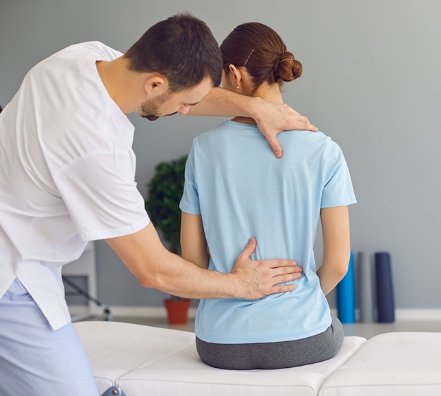 Woman sat down having chiropractic treatment