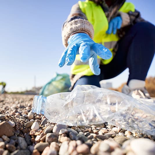 Person litter picking on a shingle beach