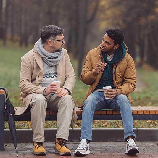 Two men talking about their anxiety outside over a coffee