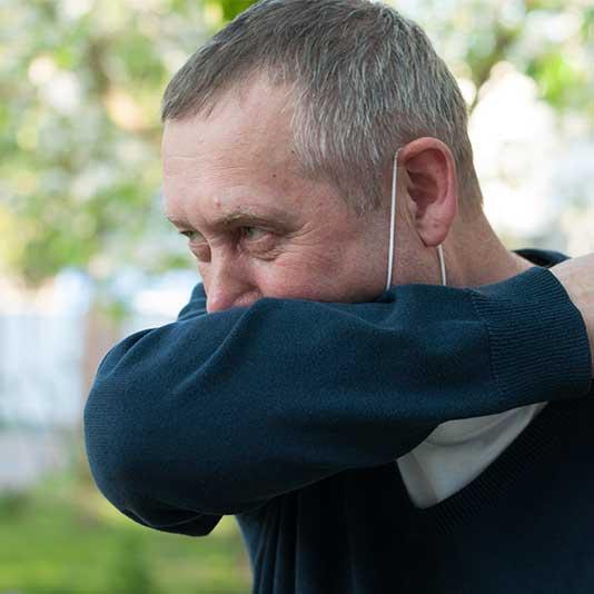 Man coughing into elbow