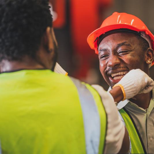 Two men elbow pumping on building site