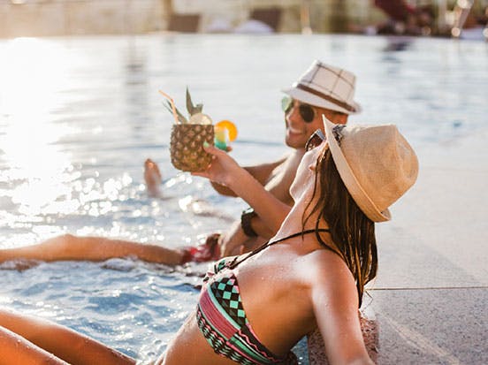 Couple drinking cocktails in the pool on holiday