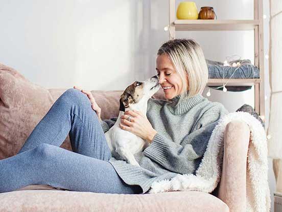 Lady lying on sofa with small dog