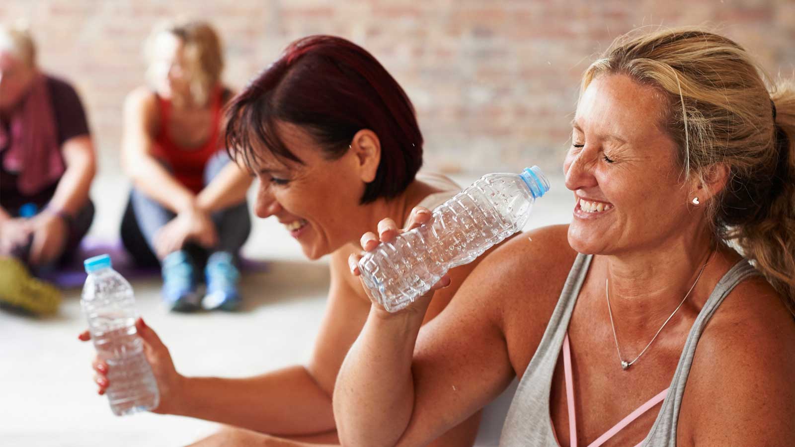 Women laughing drinking water at exercise class