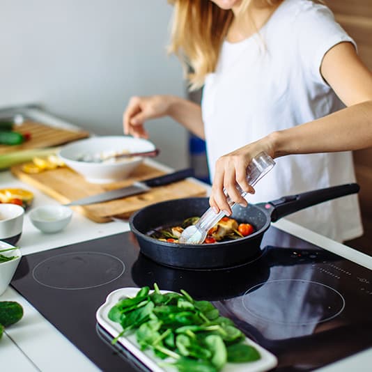 Woman cooking healthy stir fry in kitchen